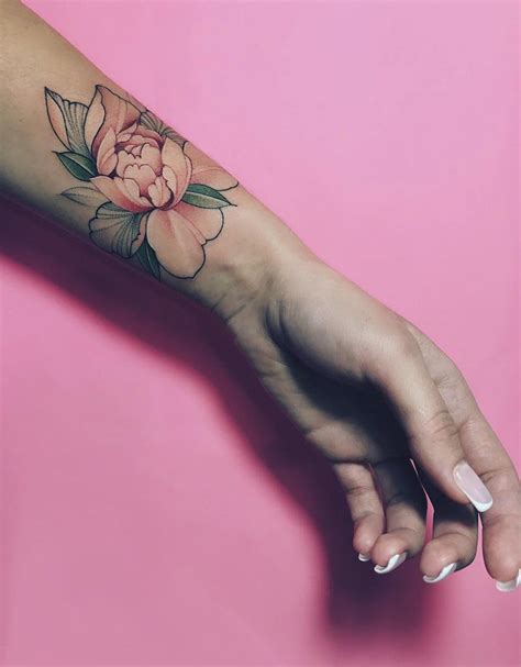 A Womans Hand With A Flower Tattoo On It