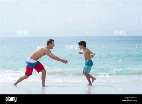 Father Chasing Son At Beach Stock Photo Alamy