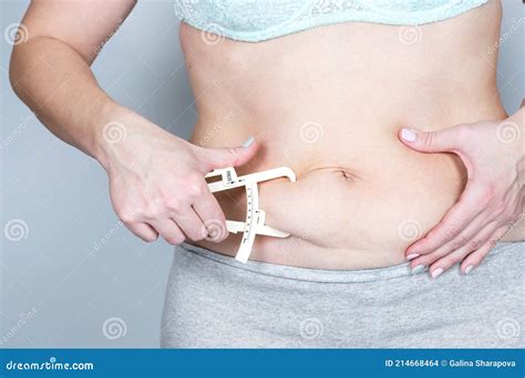 Overweight Or Fat Adult Woman Measures The Fat Fold On The Abdomen With