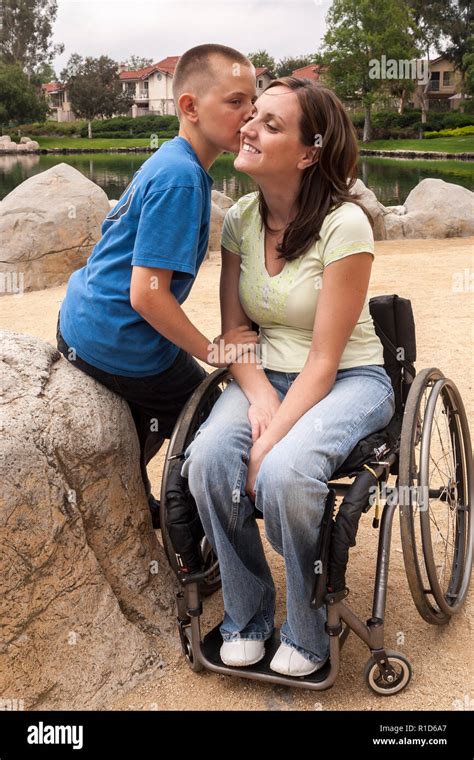 Son Kissing Cheek Of Disabled Mother In Wheelchair © Myrleen Pearson