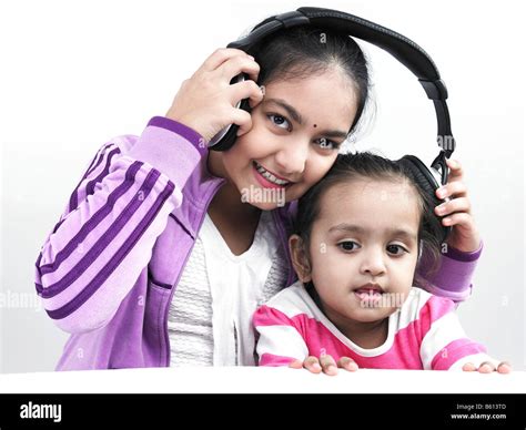 Portrait Of Two Asian Sisters Listening To Music With One Headphone