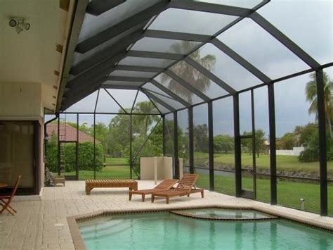 The fire pit patio includes a seat wall for overflow seating around the fire feature (which doubles as a retaining wall) with ample room for chairs. 20 Beautiful Glass Enclosed Patio Ideas