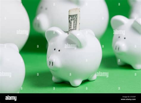 Rows Of Piggy Banks With Money Coming Out Of Slot Stock Photo Alamy