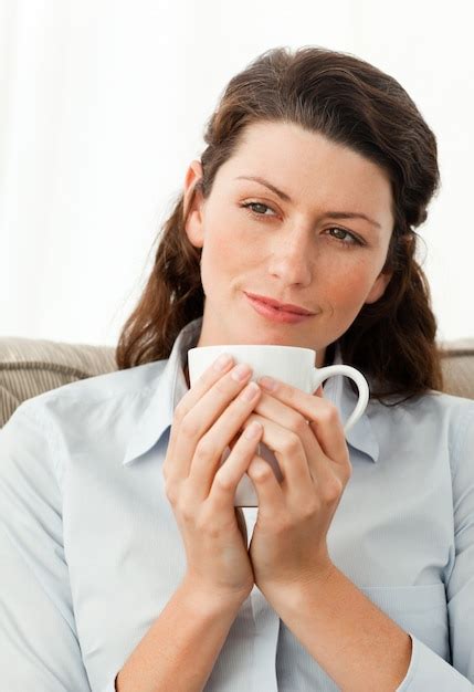 Premium Photo Pretty Woman Holding A Cup Of Coffee Sitting On The Sofa