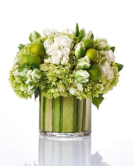 A Vase Filled With Lots Of Green And White Flowers
