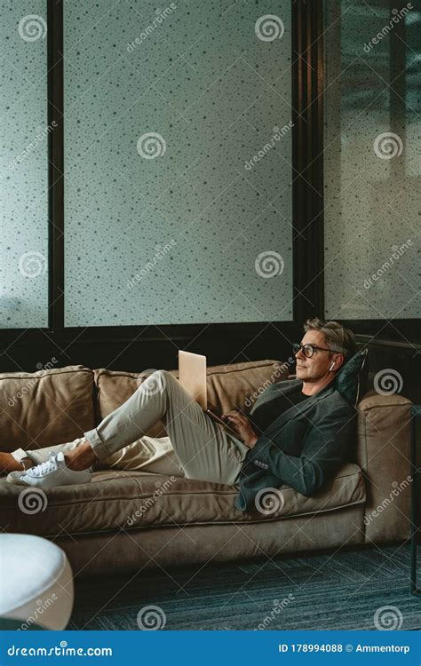 Businessman Lying On The Sofa Working On Laptop Stock Photo Image Of
