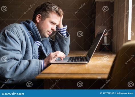 Handsome Young Man Checks Mail On A Laptop Sitting Near Window Stock