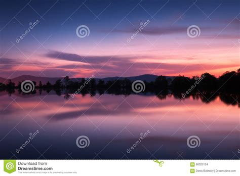 Mountain Lake With Stars And Reflected Clouds In Water Night Stock