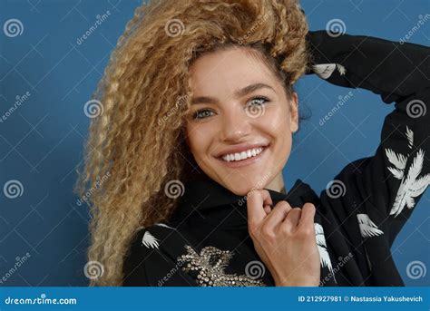 Portrait Of Young Happy Beautiful Woman With Blond Curly Hair On Blue Background Stock Image