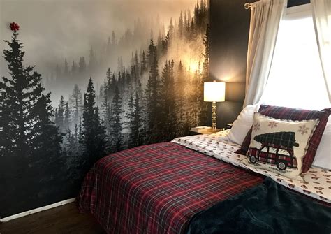 A Bedroom Decorated In Black And White With Trees Painted On The Wall