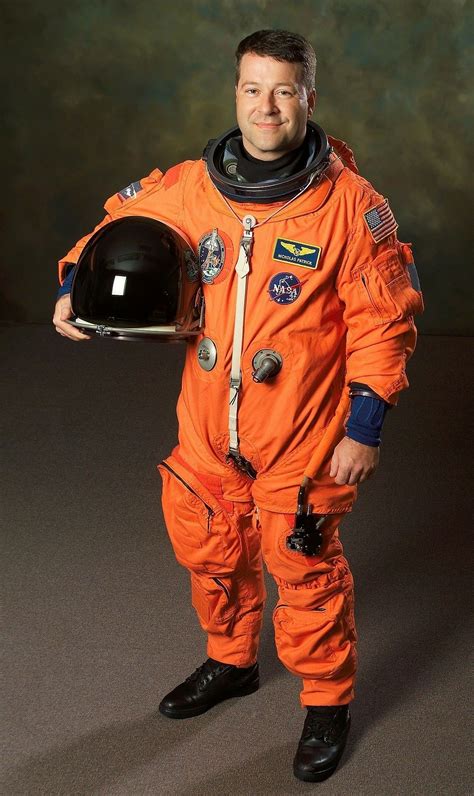 A Man In An Orange Space Suit Is Holding A Helmet And Looking At The Camera