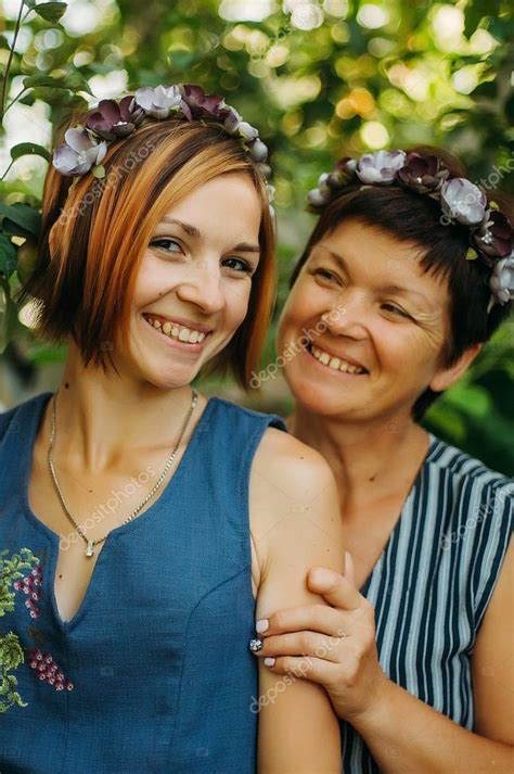 Retrato De Una Madre Y Una Hija Sonrientes Posando En Coronas De Flores