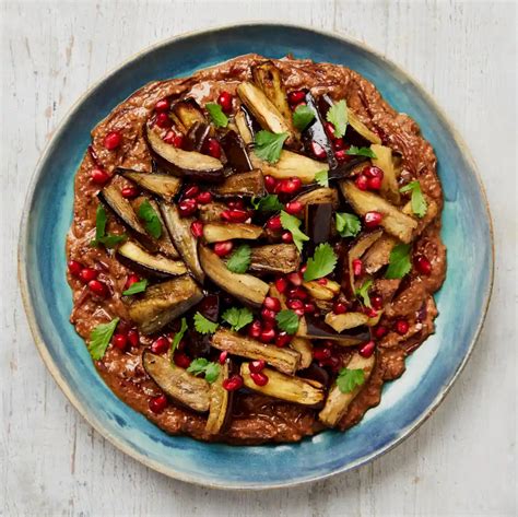 A Blue Plate Topped With Mushrooms And Pomegranate