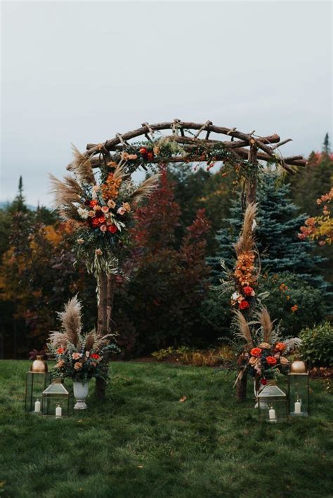 An Outdoor Ceremony Setup With Flowers Candles And Greenery On The Grass In Front Of Trees