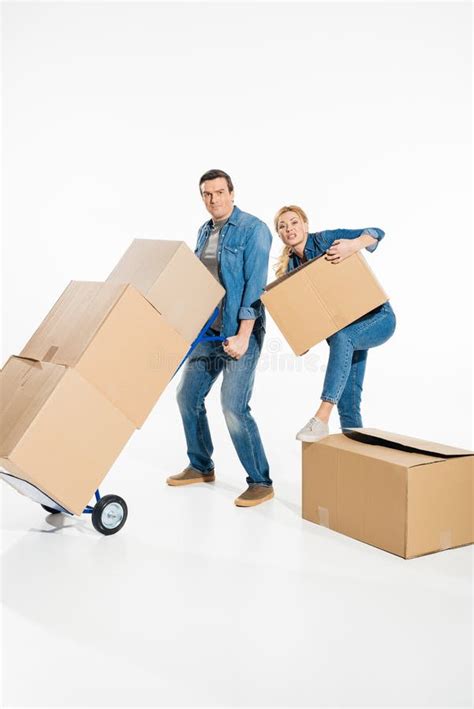 Young Couple Moving Cardboard Boxes With Trolley Cart Stock Image