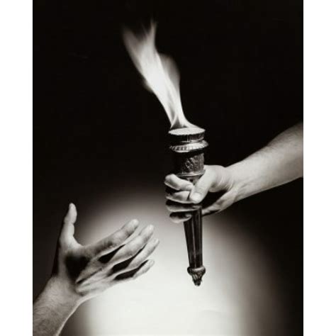Close Up Of A Persons Hand Passing A Flaming Torch To Another Person