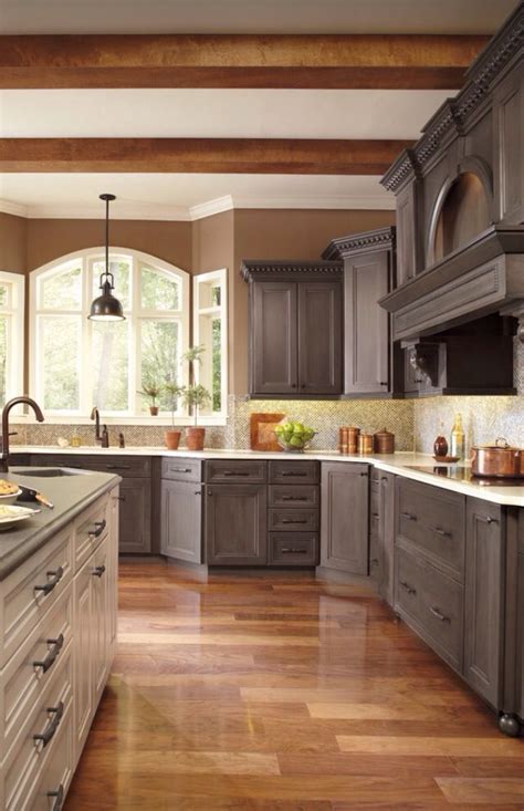 The wood gray shaker style cabinets with crown molding are in great harmony with the wood shelves and old brown brick backsplash wall! Different colors! Gray cabinets, green tile, brown walls ...