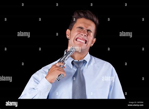 Stressed Young Businessman With A Gun Pointing To His Head Isolated On