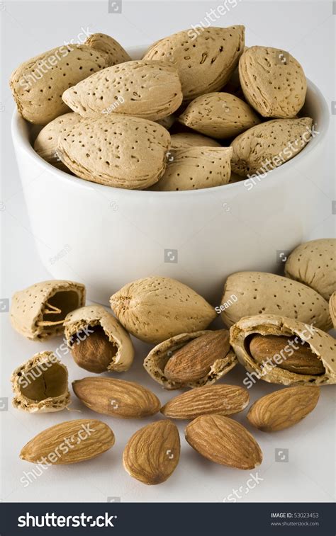 Small Cup Full Of Almonds In Shell With Some Cracked Open Stock Photo