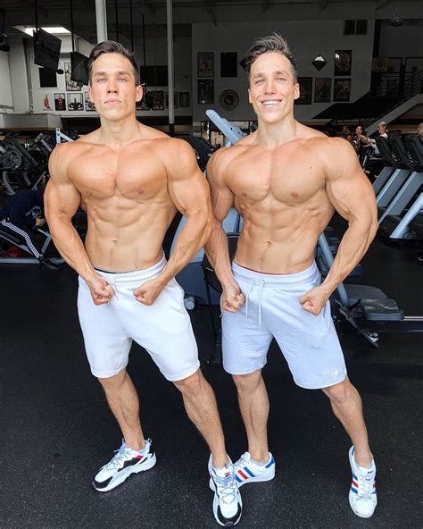 Two Men Standing Next To Each Other In The Gym