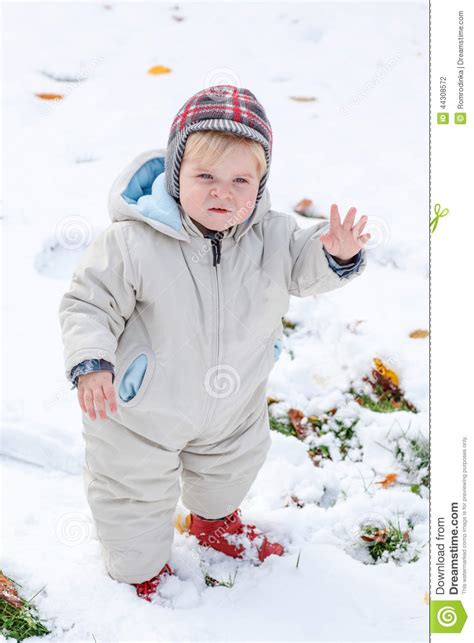 Adorable Toddler Boy Having Fun With Snow On Winter Day Stock Photo