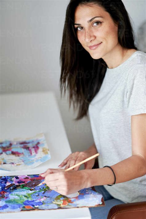 Beautiful Smiling Woman Doing Painting At Home Stock Photo