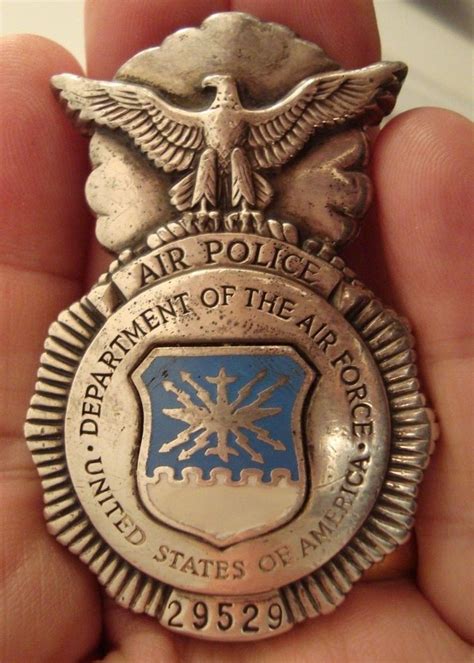 A Person Is Holding An Air Police Badge