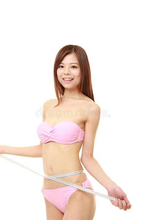 Młoda Japońska Kobieta Mierzy Jej Talię W Różowym Bikini Obraz Stock