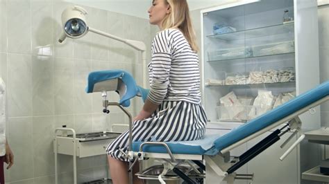 Gynecologist Asking Female Patient To Sit On Gynecological Chair For Examination Stock Footage