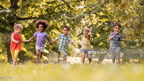 Small Happy Kids Having Fun While Running In Nature High Res Stock