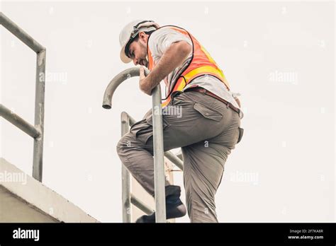 Young Man Construction Worker Or Engineer Climb Ladder On The Building