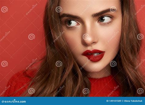 Sensuous Woman Biting Her Lips On Red Background Indoors Stock Image