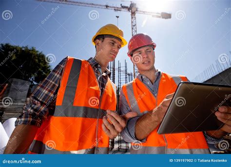 Structural Engineer And Construction Manager In Orange Work Vests And