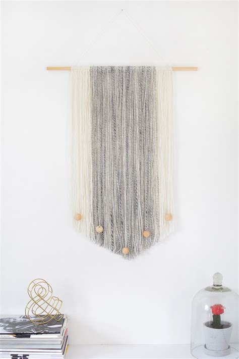 The textured wood mirror emphasizes the centrally located fireplace in this lovely symmetrical living room. DIY yarn wall hanging | BURKATRON