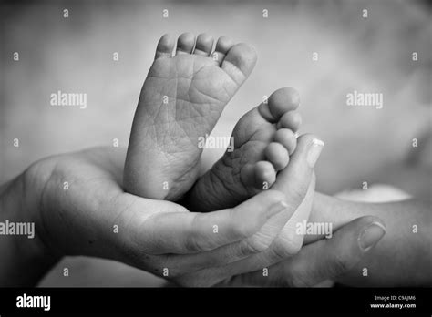 Mother Gently Holding Babys Legs Stock Photo Alamy
