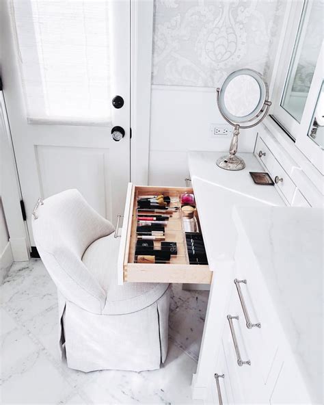 A White Chair Sitting In Front Of A Bathroom Sink Next To A Vanity With