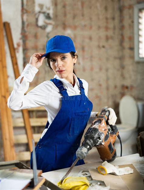 Portrait Of Female Builder With An Industrial Puncher In Her Hands