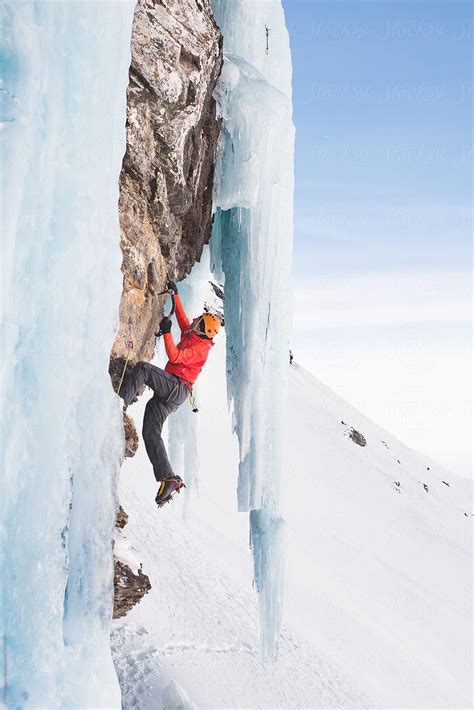 Man Ice Climbing On Steep Rock Wall In Mountains By Rgandb Images