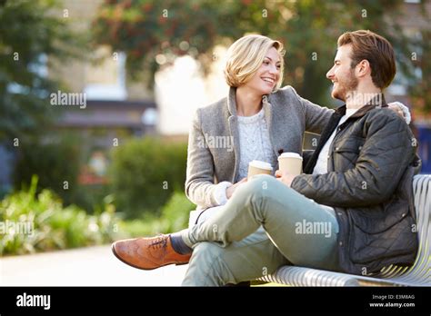 Couple Relaxing On Park Bench With Takeaway Coffee Stock Photo Alamy