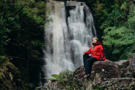 Beautiful Woman Hiker Standing At Front Of Waterfalls And Looking Away