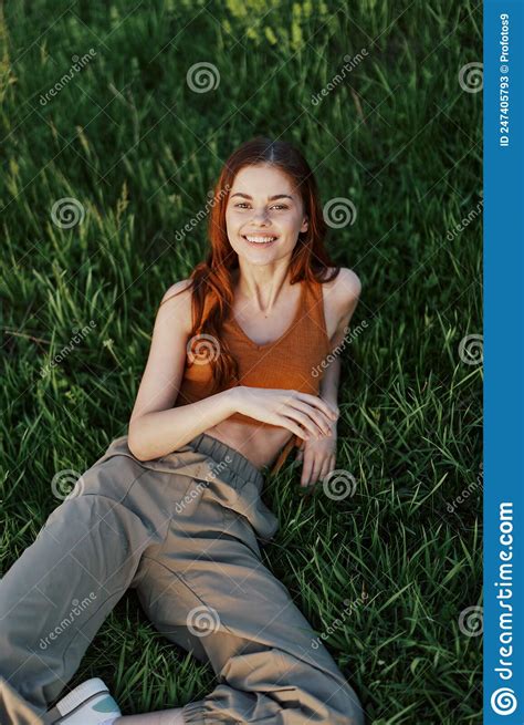 View From Above A Woman Lying On The Grass Smiling And Looking Into The Cameras Happy Lifestyle