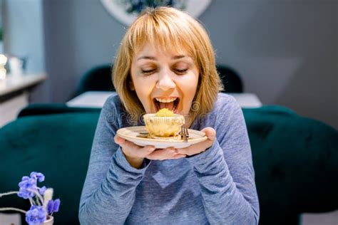 Portrait Of Young Pretty Smiling Woman Eating Cake With Big Pleasure At