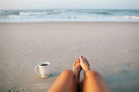 Woman And A Cup Of Coffee On The Beach In The Morning By Stocksy