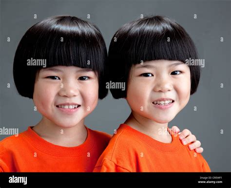 Cheerful Chinese Girl Twins Five Years Old Wearing Orange T Shirts