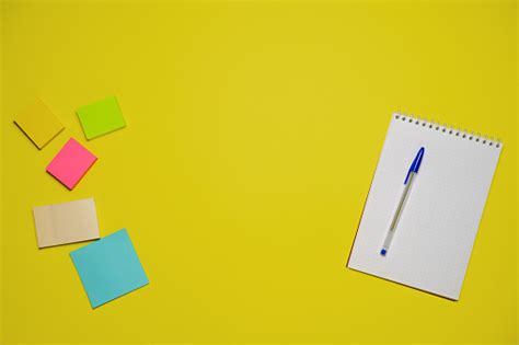 buku catatan dan pena dengan latar belakang kuning tampilan atas dengan ruang salin alat tulis