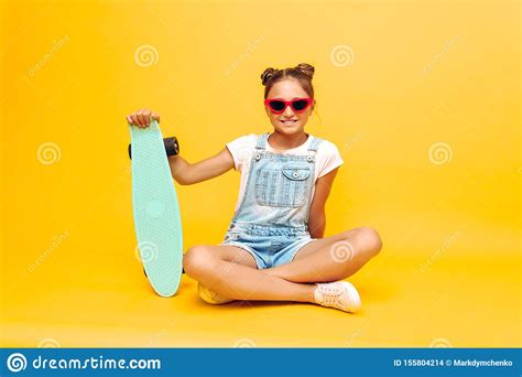 Teenager Sitting With Skateboard Stylish Girl Posing In Sunglasses On