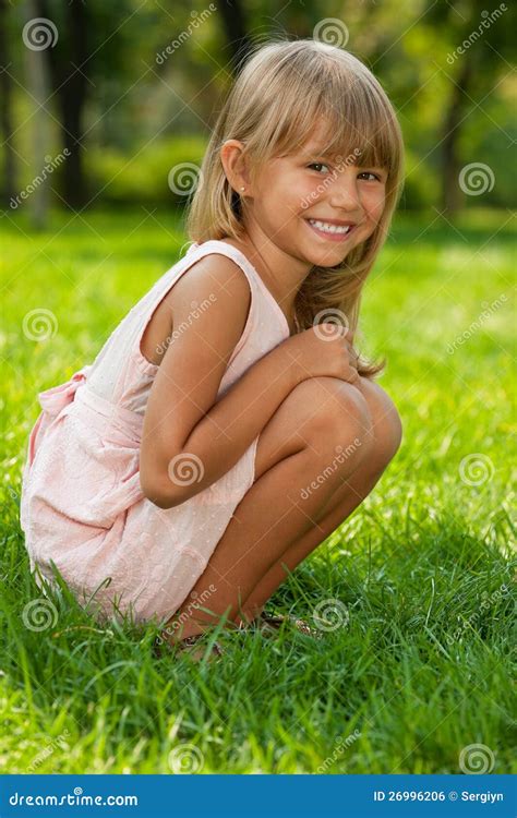 Little Girl Sits On The Grass In The Park Stock Photo Image Of