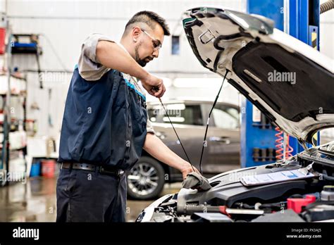 Handsome Mechanic Job In Uniform Working On Car Stock Photo Alamy