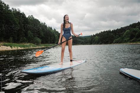 Teen Girl On Paddle Board On Lake In France By Stocksy Contributor