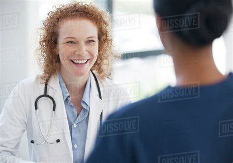 Doctor And Nurse Talking In Hospital Hallway Stock Photo Dissolve